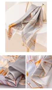 Detail view of a luxury grey silk scarf featuring elegant nautical chain prints and rolled hems.