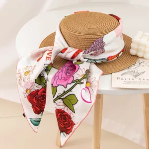 Elegant floral silk scarf wrapped around a straw hat, perfect for summer sun protection.