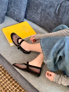 Close-up detail of black mesh flat shoes featuring a delicate strap and breathable design.