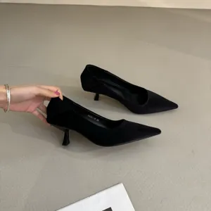 Detail view of black velvet pointed-toe kitten heels, showing refined minimalist craftsmanship.