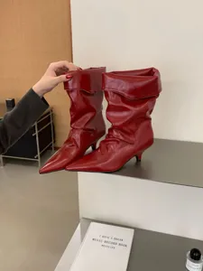 Botas rojas de tacón con puntera puntiaguda, vista detallada que destaca el elegante diseño plisado chic.