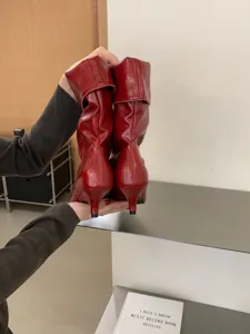 Vista detallada de botas rojas brillantes con tacón kitten, elegante punta afilada.