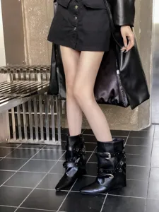 Bottines noires à bout pointu et talon compensé avec boucles et rivets élégants pour femmes.