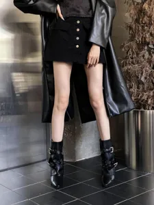 Vue détaillée de bottines noires élégantes à bout pointu et boucles métalliques, style automne.