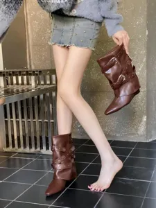 Vue détaillée des bottes mi-mollet marron à bout pointu compensé et boucles.