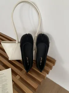 Scarpe basse Mary Jane nere con punta divisa e suola morbida per comfort quotidiano.