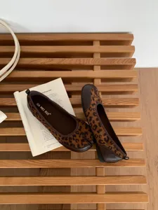 Dettaglio scarpe basse con punta spaccata leopardata, pelle marrone stile retrò donna.