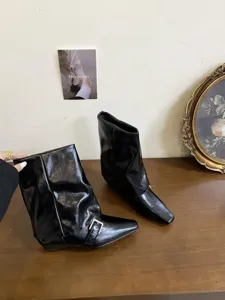 Primo piano dettagliato di stivaletti neri in pelle con punta quadrata ed elegante.
