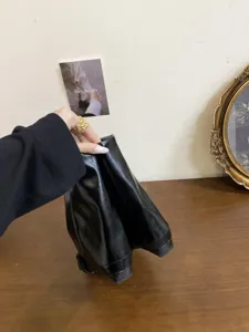 Dettaglio di stivaletti neri da donna con punta quadrata e tacco basso, mostra la suola.