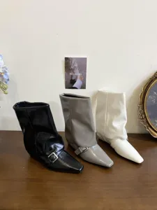 Vista dettagliata di stivaletti da donna eleganti con punta quadrata e fibbia alla moda.
