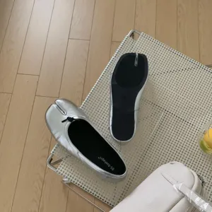 Silver split toe ballet flat detail, lifestyle shot showcasing unique tabi design and texture.