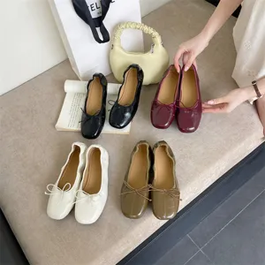 Detailed view of women's vintage flat ballet shoes with soft leather and delicate bows.