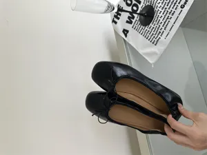 Detail shot of black square toe flat ballet shoes, elegant soft leather and delicate straps.