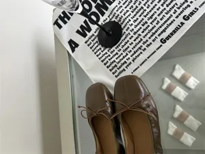Retro flat ballet shoes for women, shallow cut design with strap bow, elegant brown leather.