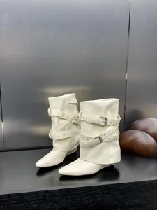 Bottes compensées blanches pointues pour femmes avec lanières à boucles et rivets.