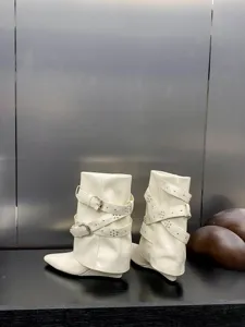 Vue détaillée de bottes à talons compensés blanches avec brides et clous métalliques.