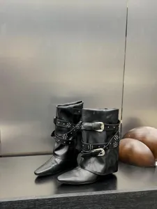 Bottes compensées noires à bout pointu avec lanières à boucles et rivets pour femmes.