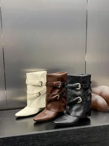 Vue détaillée de bottes mi-mollet à bout pointu compensées avec boucles et rivets.
