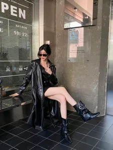 Vue détaillée de bottes noires pointues élégantes avec boucles et rivets en métal.