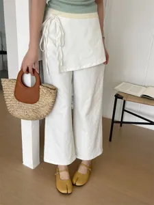 Detail view of stylish split-toe Mary Jane shoes paired with a casual white outfit and bag.