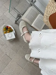Vista dettagliata delle scarpe basse beige intrecciate e traspiranti da donna con cinturino autunnale.