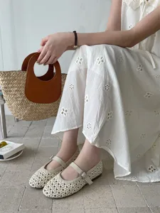 Vista dettagliata di scarpe basse da donna traforate e traspiranti con cinturino con fibbia.