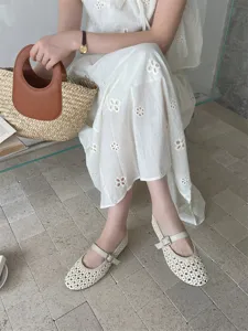 Primo piano di eleganti ballerine traforate e traspiranti con cinturino a fibbia.