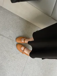 Dettaglio scarpe basse intrecciate traforate, Mary Jane marrone con fibbia elegante.