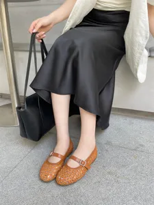 Dettaglio delle ballerine Mary Jane marroni intrecciate con design traforato traspirante e fibbia.