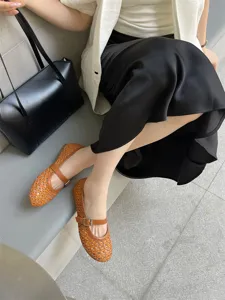 Dettaglio di scarpe basse Mary Jane marroni traforate e traspiranti, stile moda autunnale.