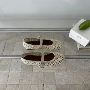 Scarpe basse Mary Jane beige intrecciate con design traforato e cinturino elegante.