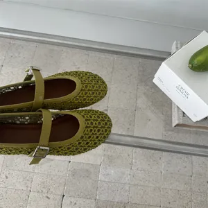 Vista dall'alto dettagliata di scarpe Mary Jane in rete verde con fibbia, traspiranti.