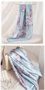 Detail view of light blue silk scarf, elegant floral pattern and delicate fabric texture display.
