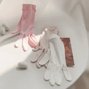 Detail view of long silk gloves in pink, nude and white, soft fabric features delicate ribbed cuffs.