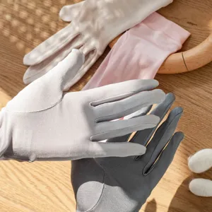 Detail view of thin knit silk sun protection gloves showing soft texture and colors.