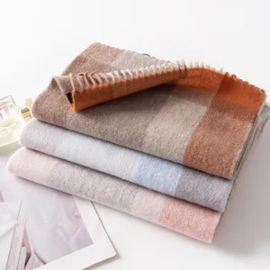 Vue rapprochée détaillée d'écharpe à franges pour femme en laine douce et chaude.