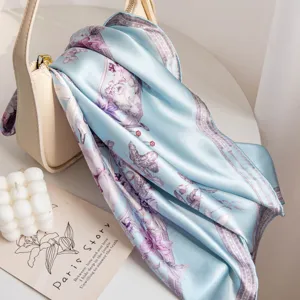 Elegant light blue silk scarf draped over a handbag, main view product presentation
