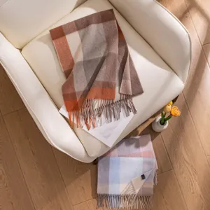 Vue détaillée de l'écharpe à carreaux en laine à franges dans un décor chaleureux.