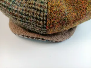 Close-up detail of the vintage wool tweed newsboy hat, showing multi-color fabric texture.