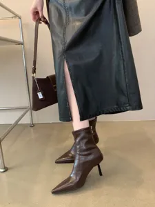 Vista detallada de botines marrones para mujer con tacón alto y punta fina elegante.