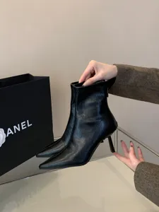 Elegantes botines negros de mujer con tacón de aguja y punta fina, vista de detalle.