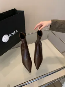 Vista detallada de botines marrones de punta fina y tacón alto con diseño elegante y sofisticado.