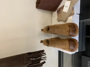 Detailed view of women's brown suede chelsea boots with chunky lug sole and retro design.