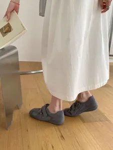 Grey suede and mesh Mary Jane flat shoes detail close-up, elegant casual footwear style.