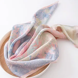 Luxurious pure silk square scarf featuring vibrant tropical jungle print and elegant drape.