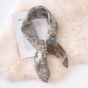 Detailed view of luxury silk twilly scarf with tropical jungle print, elegant neck accessory.