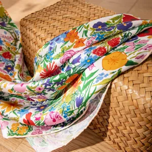 Close-up of vibrant floral silk scarf showing soft fabric texture and colorful botanical print details.