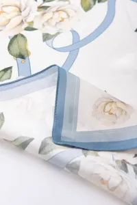 Luxury mulberry silk square scarf featuring elegant white camellia flowers and blue ribbons.