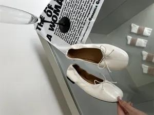 Stylish white flat ballet shoes for women, featuring shallow mouth and cute bow detail.