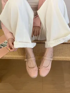 Vue détaillée de chaussures Mary Jane plates roses avec nœud délicat et bride, style chic.